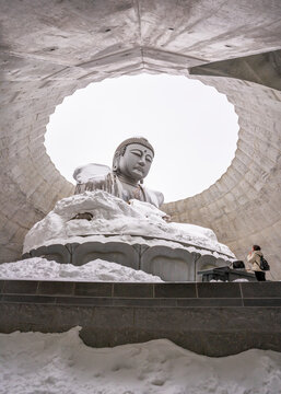 View of snow-covered Makomanai Takino Cemetery with a large buddha statue and award-winning architecture, Sapporo, Hokkaido Prefecture, Japan.