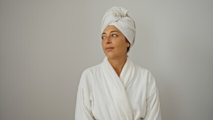 Woman wearing bathrobe and towel on head, looking sideways against isolated white background