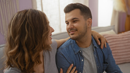 Couple sharing a loving moment at home, with a man and woman sitting close together in a cozy living room