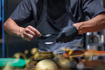 Gros plan sur un chef étoilé qui prépare un menu à base de caviar.