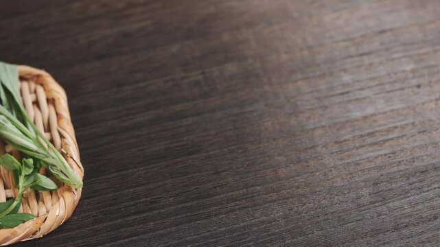木目テーブルに置かれた竹笊と春の七草