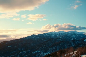 A vast mountain range cloaked in snow showcases stunning peaks and clouds that create an awe-inspiring atmosphere, offering beautiful natural scenery and tranquility