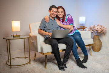 Comfortably seated, a couple engages with the digital world on their laptop, embracing togetherness and innovation.