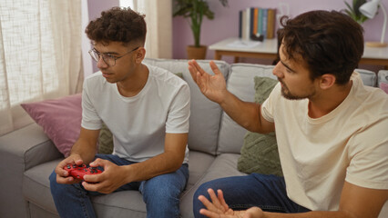 Father and son bonding at home with a video game controller in the living room