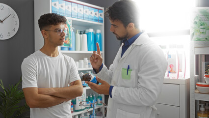 Obraz premium Pharmacist advising young man in a pharmacy on medication with shelves in the background