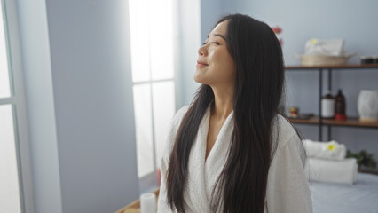 Young chinese woman relaxing in an indoor spa center with a tranquil smile