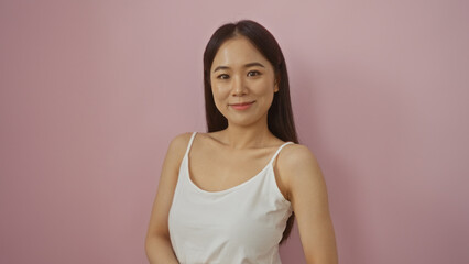 Obraz premium Attractive young asian woman posing against a pink background