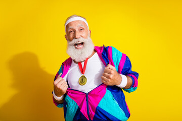 Photo of funky charismatic sportive man show golden medal vintage sportswear isolated on yellow color background