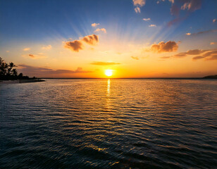 A calm sea reflecting the warm hues of a setting sun in the evening