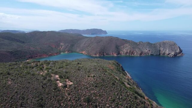 Majestic cliffs and turquoise waters at Playa Manare, Mochima National Park, Venezuela. A breathtaking drone view of coastal rock formations, lush vegetation, and pristine ocean scenery