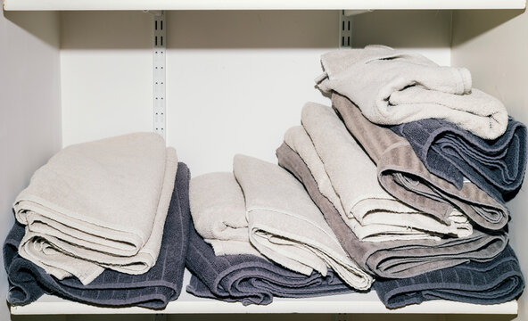 Flash photo of pile of loosely folded towels in bathroom closet