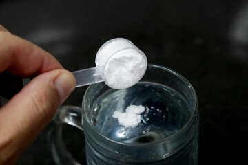 Colher de 5g de creatina pura na agua pronta para consumo humano.