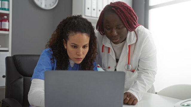 Women collaborating in healthcare office with diverse backgrounds discussing medical cases indoors using laptop for efficient teamwork. - Powered by Adobe