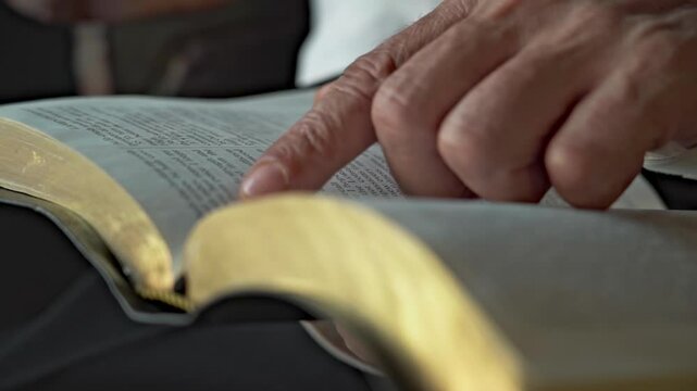bald man with glasses open the book of the bible and read it daytime in a retro room