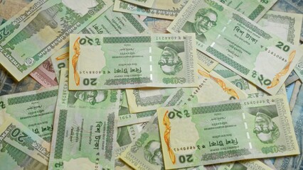 Bangladesh banknotes featuring various denominations of taka currency laid out in a scattered fashion emphasizing the financial elements of bangladeshi money.