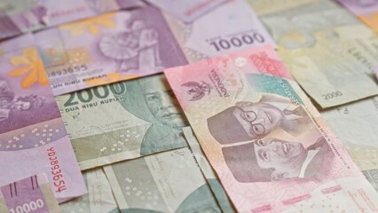 Obraz premium Closeup of colorful indonesian rupiah banknotes laid out, showcasing various denominations and portraits.