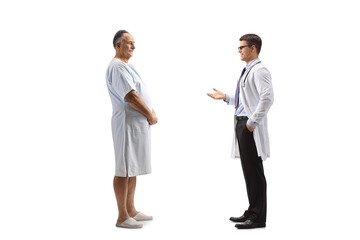 Male doctor talking to a patient in a hospital gown