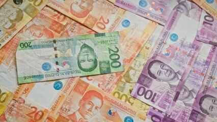 Philippine banknotes of various denominations spread on a surface, showcasing vibrant colors and detailed designs of national heroes.