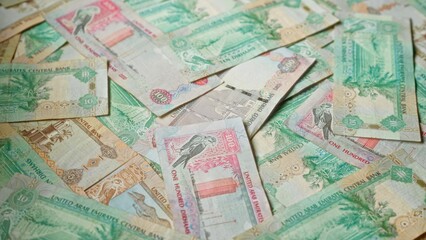 United arab emirates dirham banknotes in various denominations scattered showcasing uae currency.