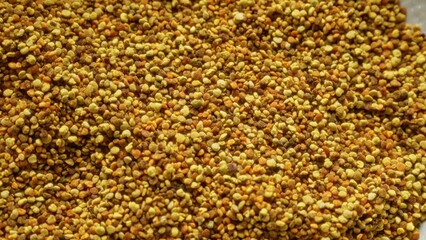 Closeup of bee pollen granules showcasing vibrant colors and natural texture.