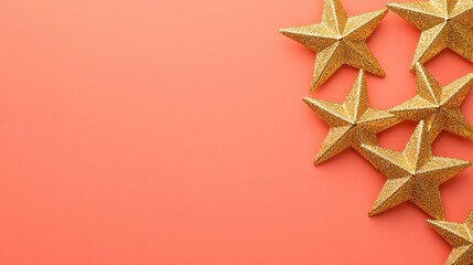 golden star ornament arranged on smooth coral background with subtle highlights