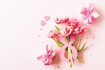 Fototapeta premium Number eight with bouquet of tulips on a pink background. International Women's Day concept