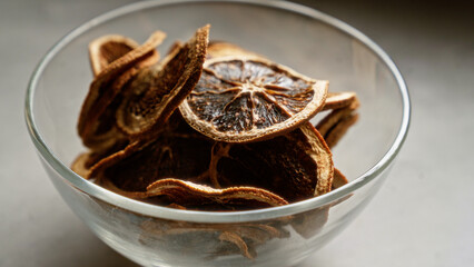 Dried lemons in a transparent bowl on a kitchen counter suggesting freshness and natural ingredients for cooking or snacking