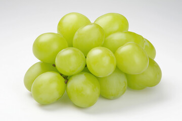Fresh green grapes clustered together on a white surface for healthy snacking