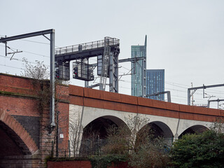 Urban landscape featuring a railway viaduct and modern skyscrapers in the background.