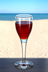 Cordial glass with liquor on the wooden table in the beach bar. Picturesque background with sand and sea. Glassware with the drink. 3d rendering.