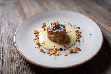 Baked Apples Stuffed with Walnuts and Vanilla Cream Sauce on a Rustic Wooden Background