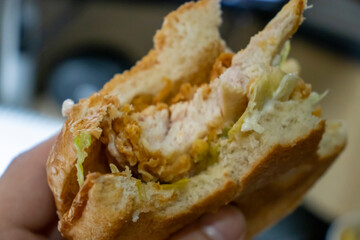 Close-up of a delicious chicken sandwich with lettuce, freshly made with crispy chicken and soft bread, perfect for fast food lovers.