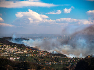 The Palisades Fire ravages homes in the Pacific Palisades with downtown LA in the background © Johnny