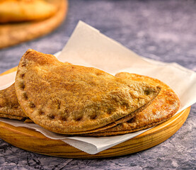 Rustic Baked Empanadas on a Wooden Plate