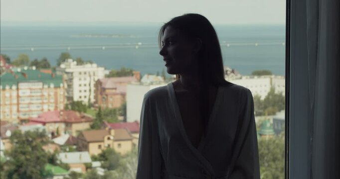 Backlit model posing by the window in hotel room