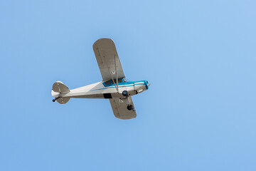 Small plane flying over the blue sky.