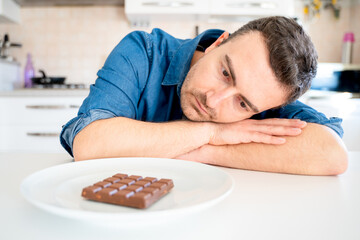 One man dieting and tempted by chocolate bar