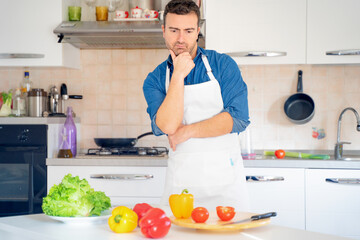 Pensive man looking for an idea to cook something