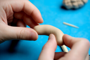 Crafting a whimsical figure from soft clay on a vibrant workspace