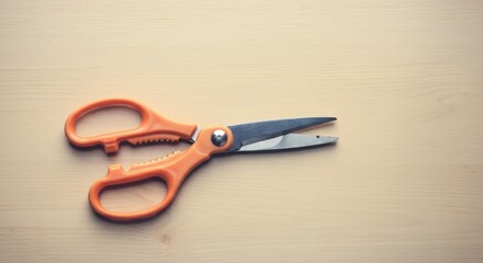 Fototapeta premium Orange scissors with serrated edge on wooden surface