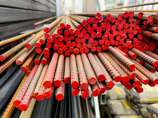 A meticulously organized and arranged stack of vibrant red metal bars forms a visually striking and...