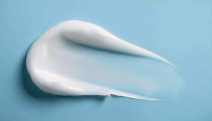 White cosmetic cream smear on pastel blue surface. Creamy texture. Skin care and beauty product