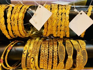 Gold Bracelets. jewelry for sale in market. elegant gold jewelry in the largest market. Rows of gold bracelets in a store. Gold on the famous Golden souk.