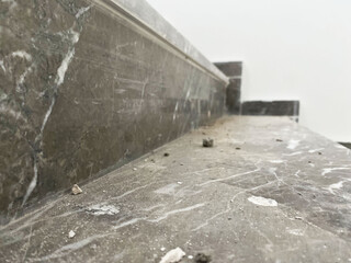 Dusty stairs in construction site. Construction dust and debris cover marble stairs in a new...