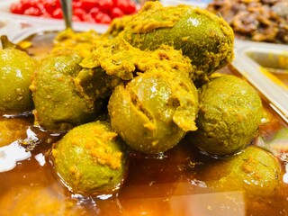 olive pickle prepared with various spices and oil. It is known as Jolpai achar. Spicy green olives are poured with olive oil with spices.