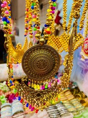 Experience the allure of opulence up close with a detailed view of gold necklaces, rings, and chains elegantly showcased in a beauty retail store window.