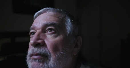 Close up of elderly man gazing upward indoors reflecting in peaceful solitude with thoughtful expression serene mood of introspection and calm