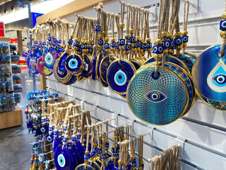 A vibrant collection of evil eye amulets, featuring intricate blue and gold designs, displayed in a...