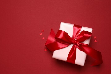 Beautiful gift box with hearts on color background