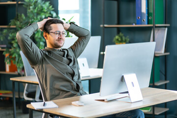 Caucasian businessman sitting at table in cafe modern cozy office looking at computer screen 